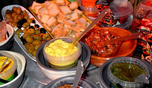 Various pieces of Gruyère cheese wrapped in parchment paper and stored in an airtight container